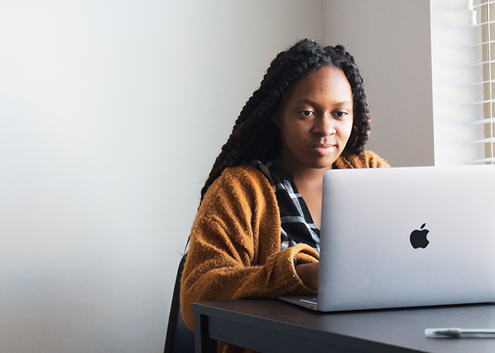 Melo-Online-Resources A woman sat at a desk looking at a laptop screen
